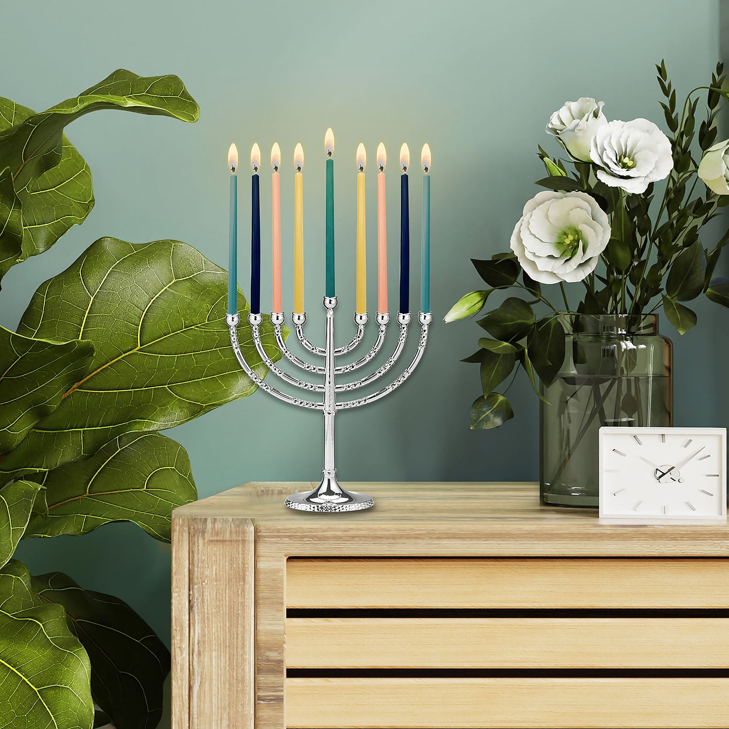 Hanukkiah with pink, yellow, teal, light blue, and blue candles lit