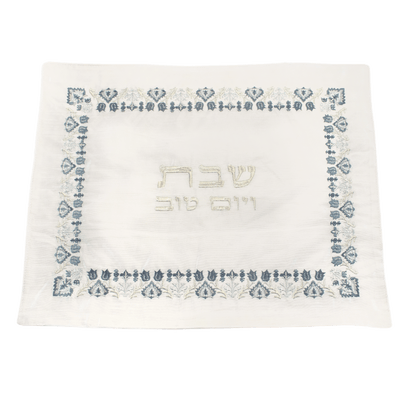 Challah cover with an embroidered border of blue-and-silver antique flowers with silver Hebrew letters in the center