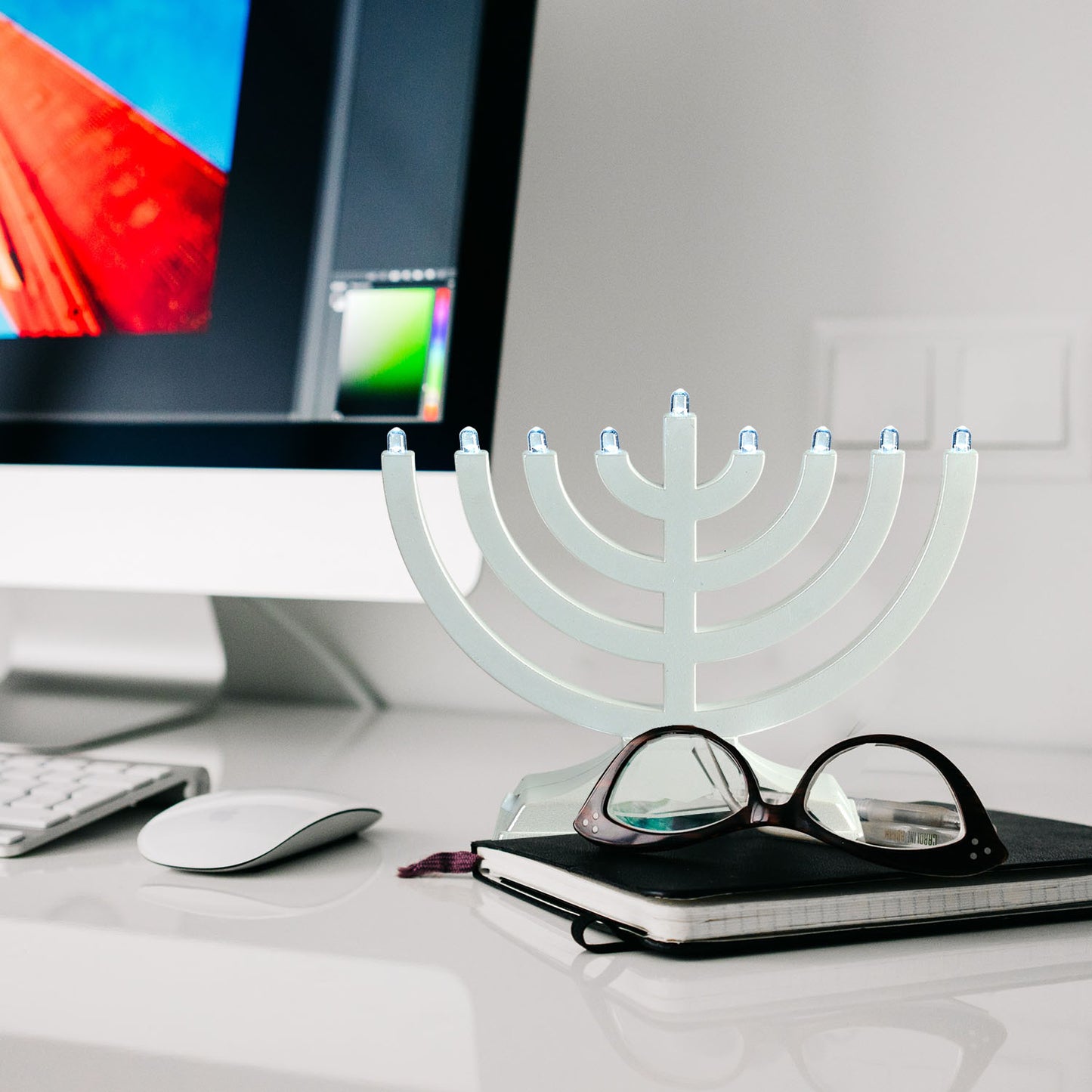A Pearl White Battery or micro-usb powered "Go Menorah" sitting on a computer desk