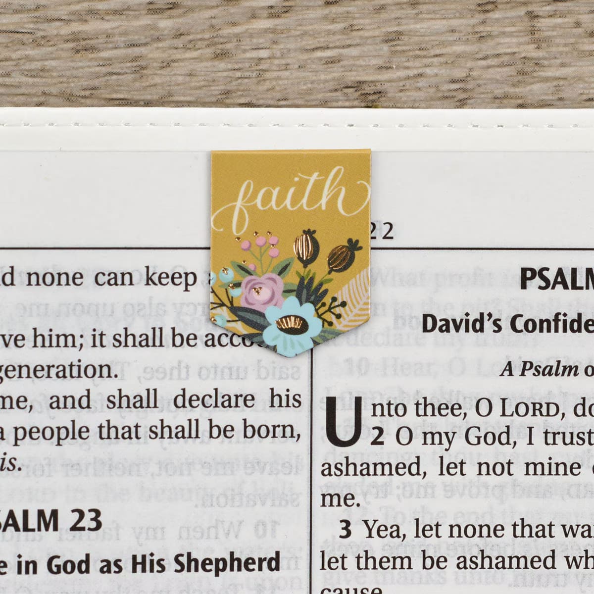 One of the bookmarks in the Faith Hope Love Die-cut Petite Magnetic Bookmark Set displayed in a Bible