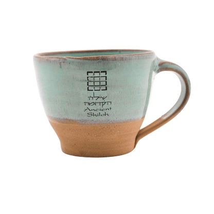 Seafoam-green ceramic mug with a breastplate design on the front; includes the message: "Ancient Shiloh" in Hebrew and English text