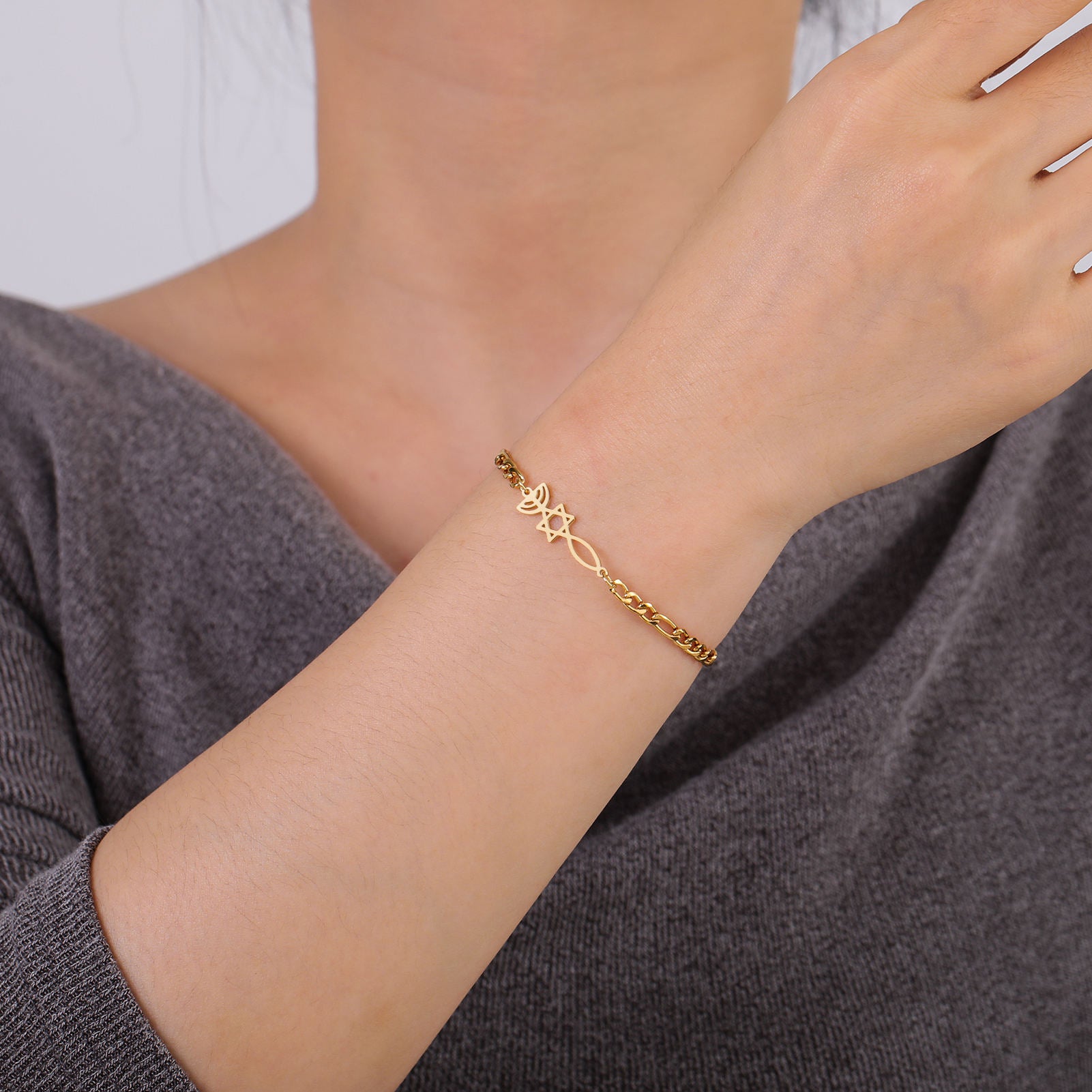 Gold-tone Grafted In bracelet with biblical symbols shown on a woman’s wrist
