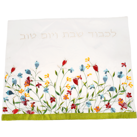Challah cover with multicolored flowers along the bottom border and silver Hebrew letters along the top border