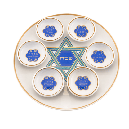 White seder plate with copper color around the border and a green and blue Star of David in the center