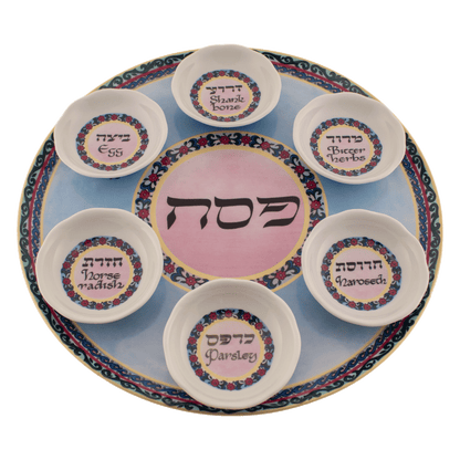 Pink and blue seder plate with a floral design and yellow trim around the edges