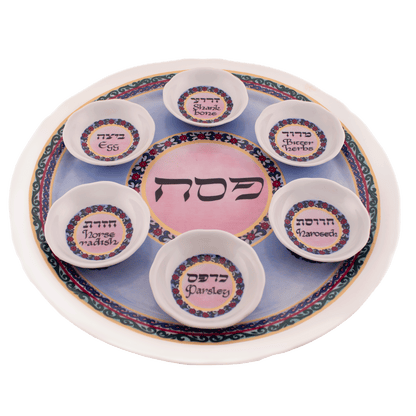 Pink and blue seder plate with a floral design and a white rim