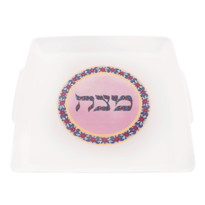 Pink and white porcelain matzah plate with a floral design in the center