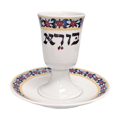 White porcelain Kiddush cup and saucer set with a floral band around the rim and saucer