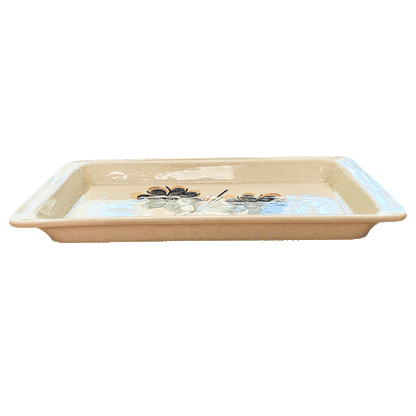 Rectangular speckled cream serving tray made of Lapid stoneware with a dark blue and yellow floral design in the bottom of the dish