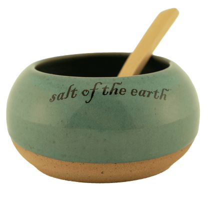 Sage ceramic salt bowl that says "salt of the earth" in English and Hebrew with a wooden spoon