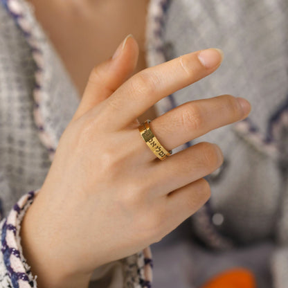 Gold Hebrew Shema inscription ring worn on a woman’s hand