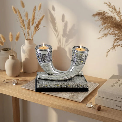 Silver shofar candlesticks displayed with candles on home table