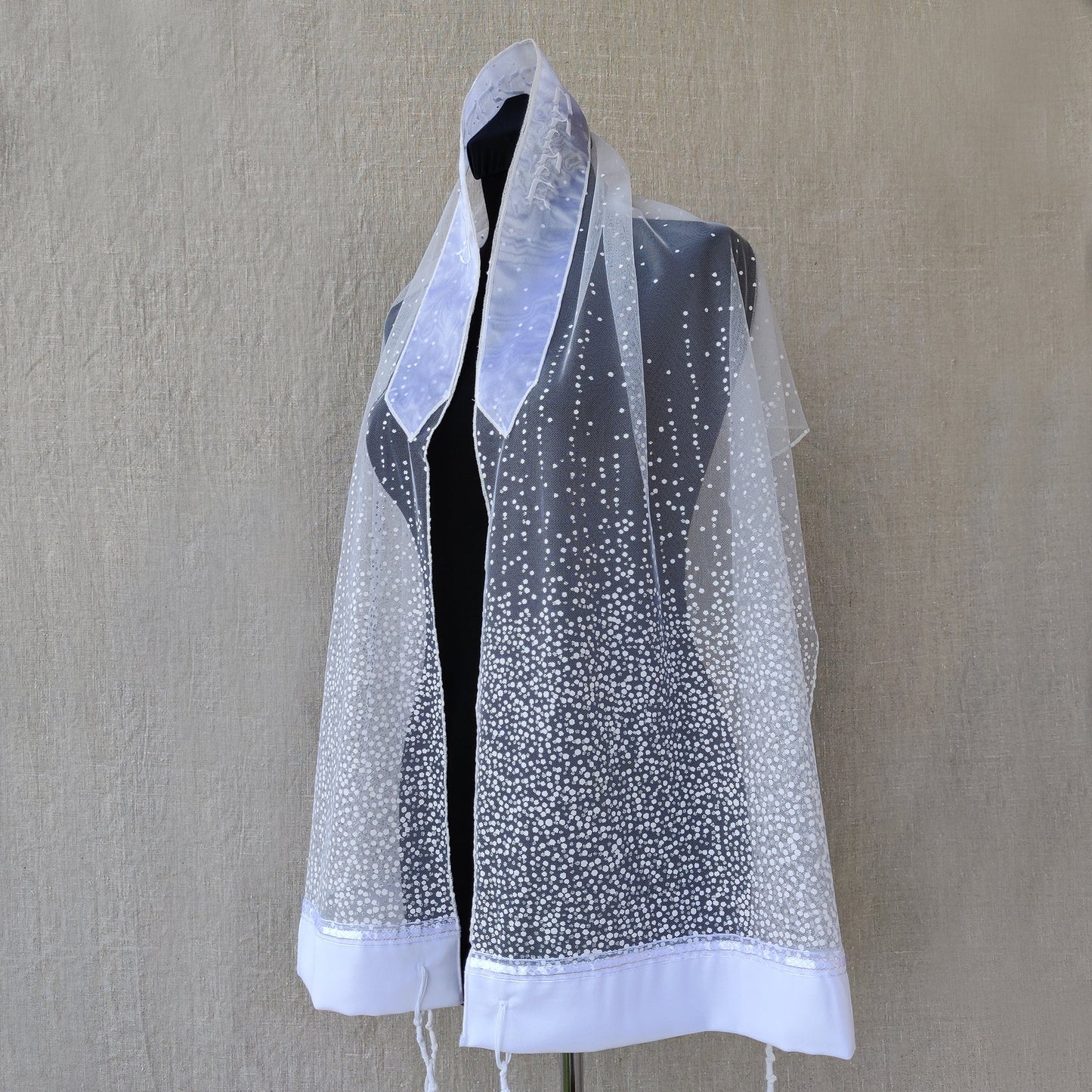 Mannequin wearing a sheer white glitter prayer shawl.