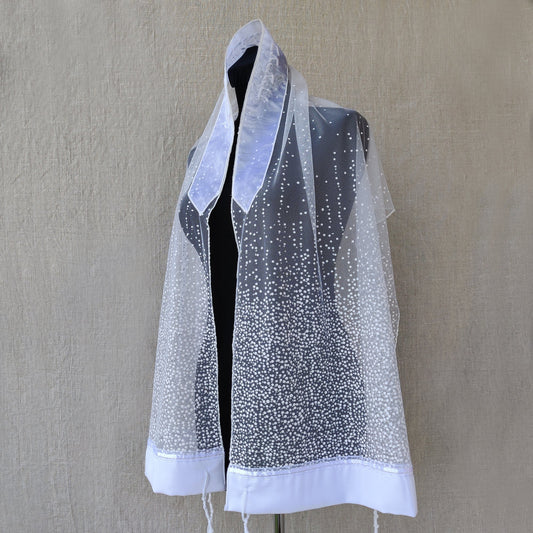 Mannequin wearing a sheer white glitter prayer shawl.