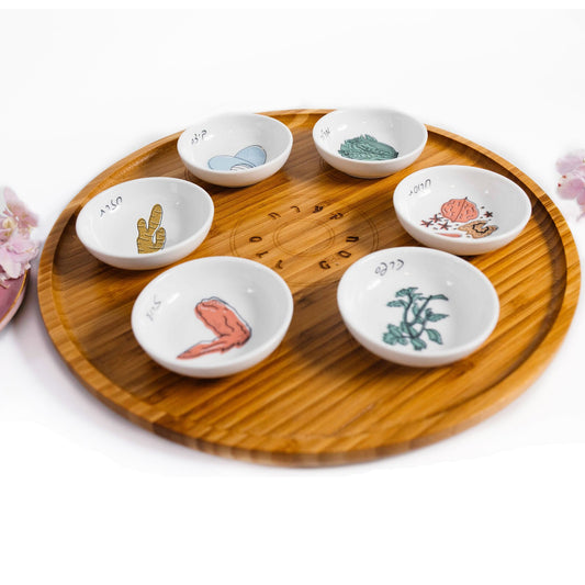 Bamboo Passover Seder plate with porcelain bowls featuring colorful illustrations shown at a close up angle