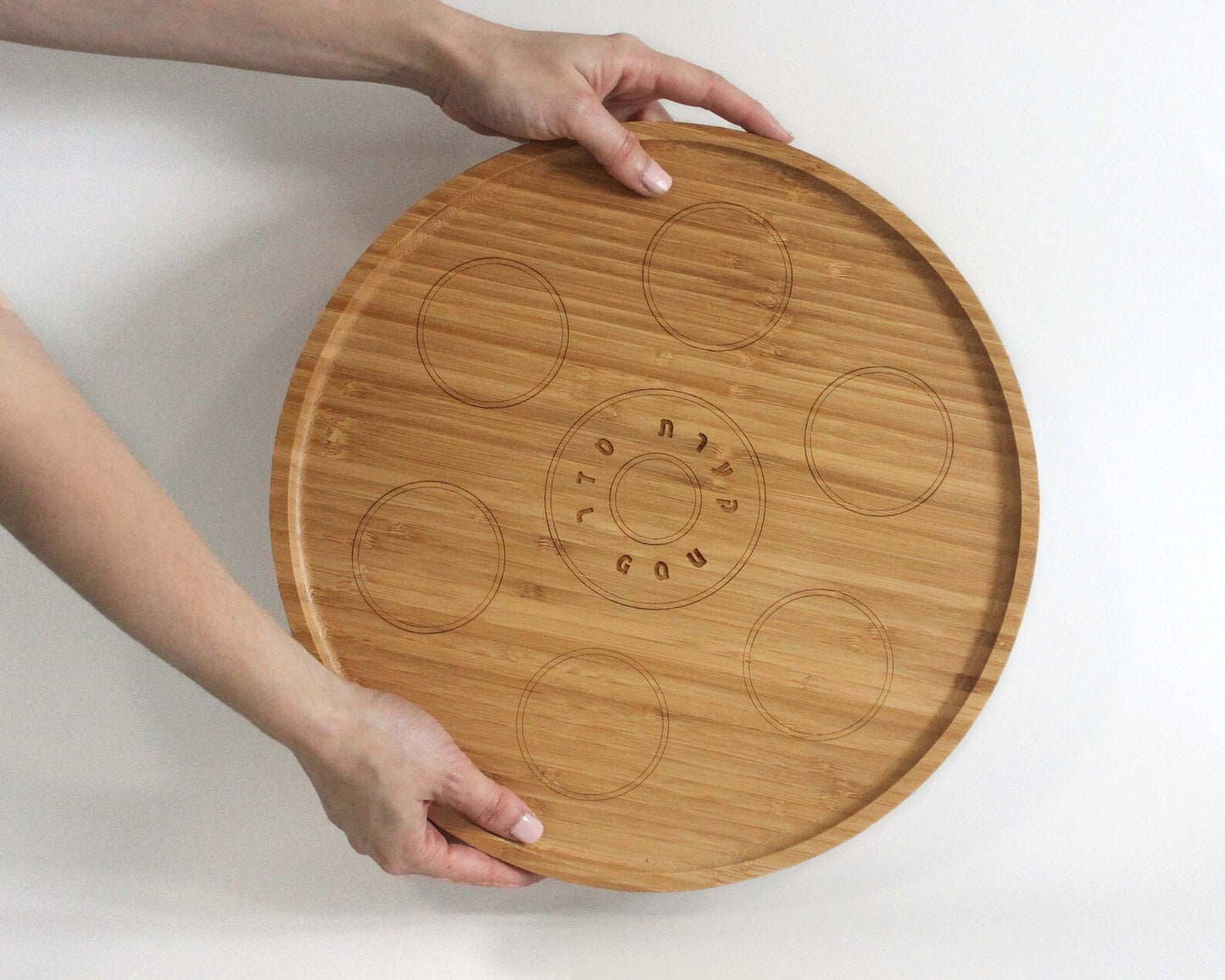 Hands holding bamboo Passover Seder plate