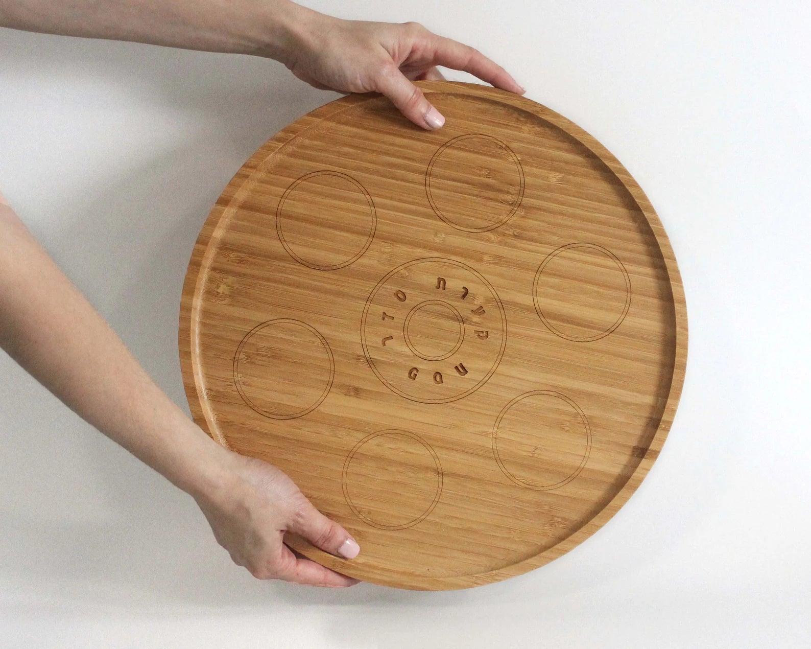 Hands holding bamboo Passover Seder plate
