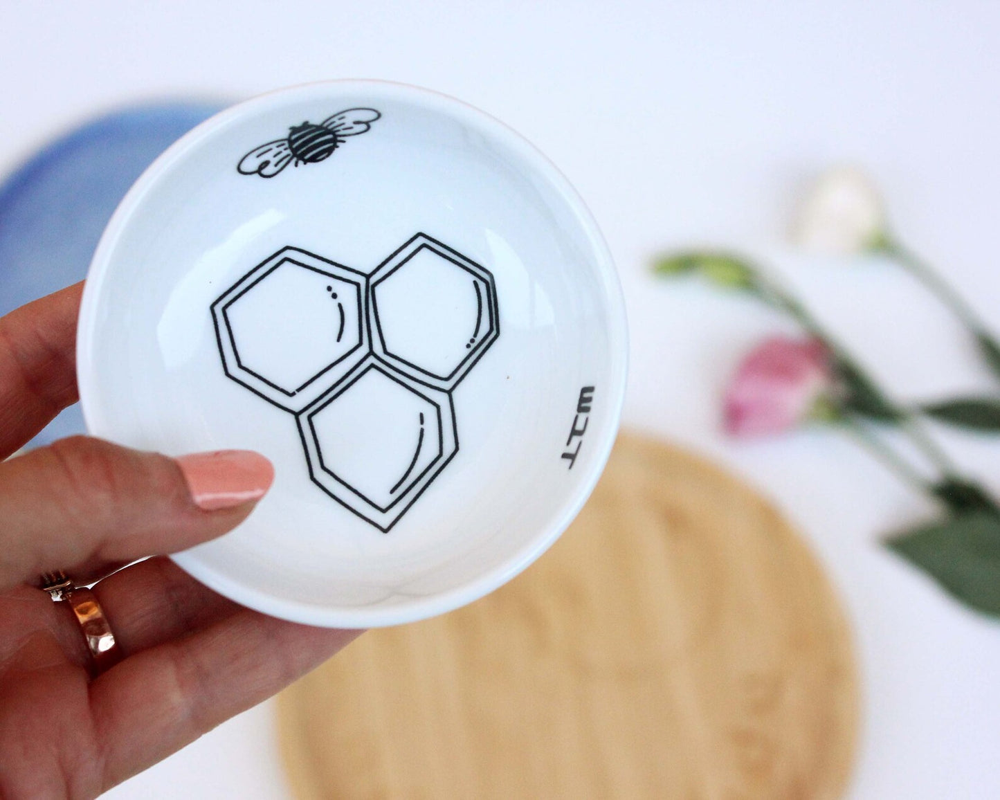Porcelain bowl with a delicate black and white illustration of a bee and honey