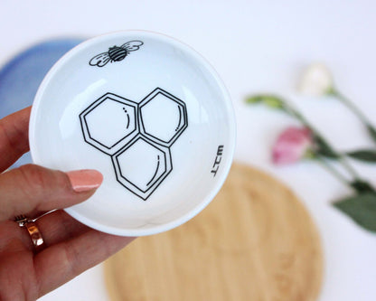 Porcelain bowl with a delicate black and white illustration of a bee and honey