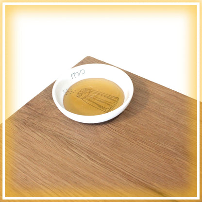 Oak Challah Board with a porcelain bowl which features an illustration of a black and white salt shaker with honey in the bowl