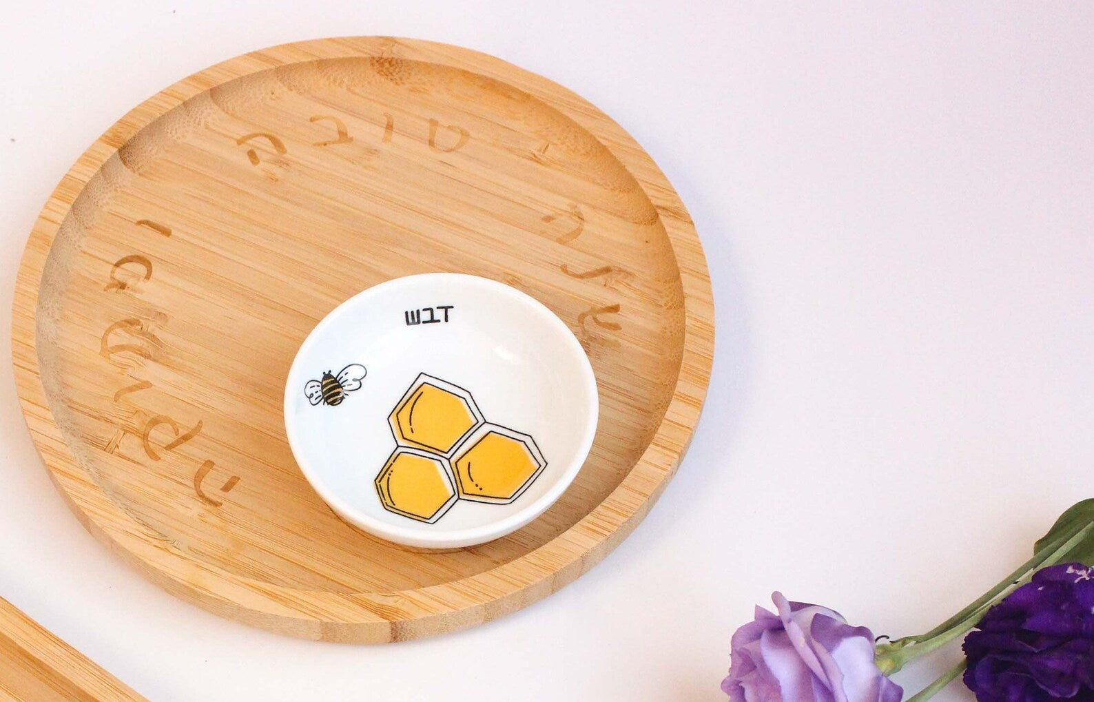 Porcelain bowl with a delicate black and yellow illustration of a bee and honey and a bamboo tray