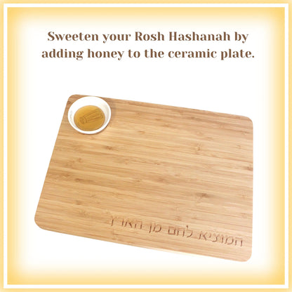 The words "Sweeten your Rosh Hashanah by adding honey to the ceramic plate." Bamboo Challah Board with a porcelain bowl which features an illustration of a blue and white salt shaker 