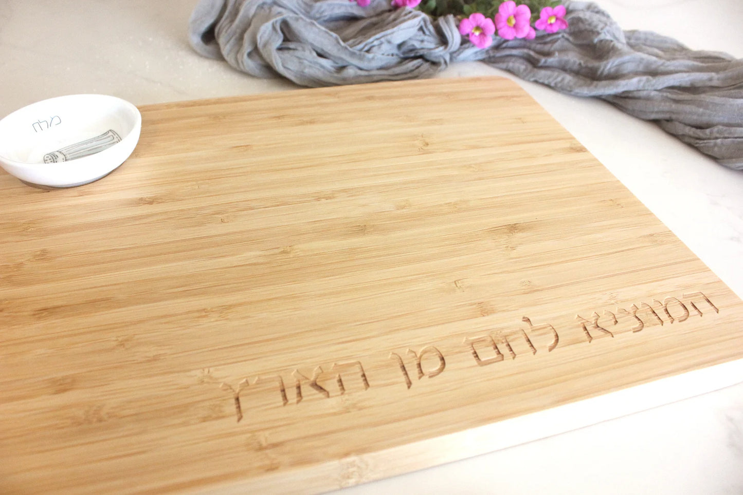 Close up of the Bamboo Challah Board with a porcelain bowl which features and illustration of a blue an white salt shaker 