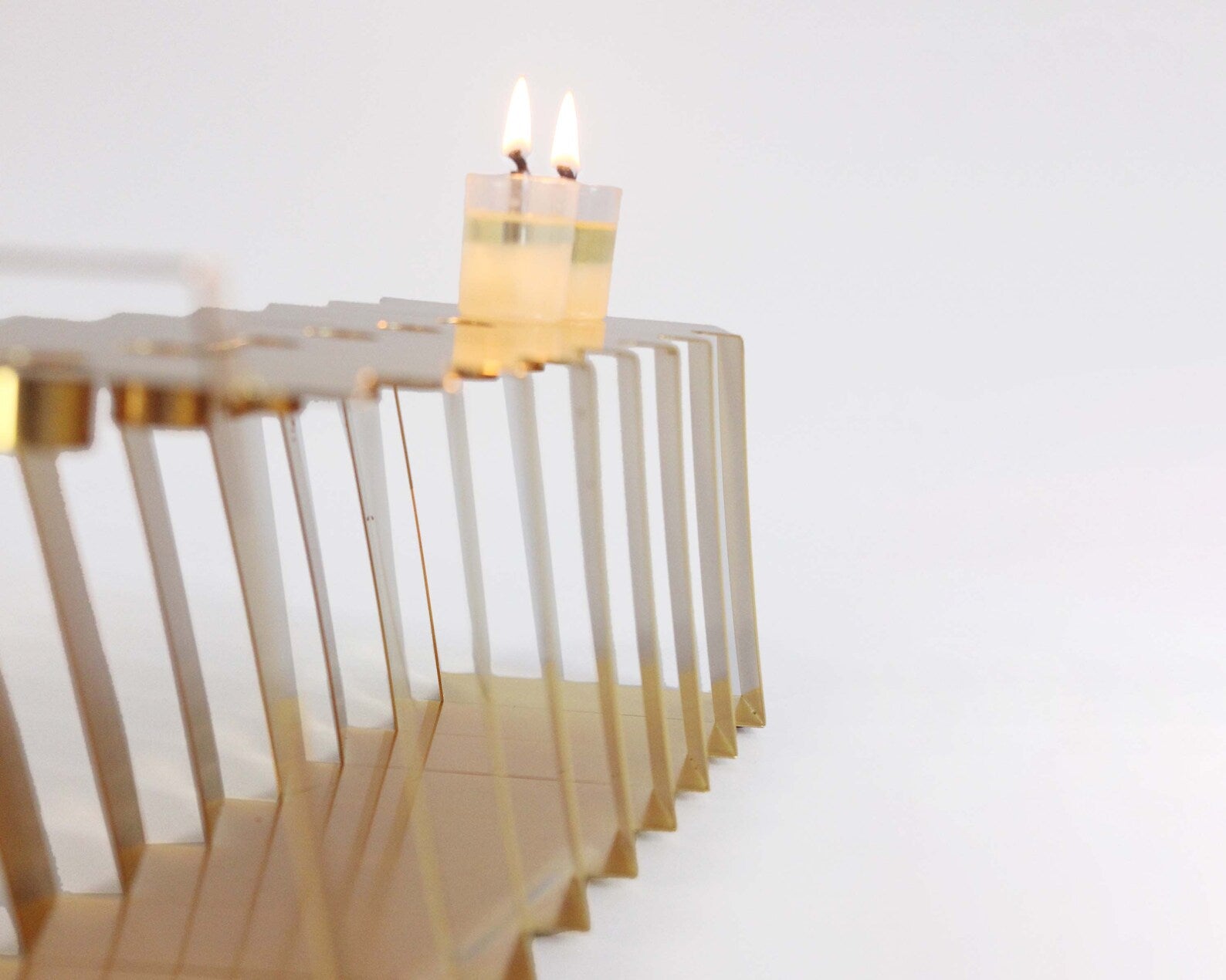 Gold Hanukkiah at an angle with two lit candles 