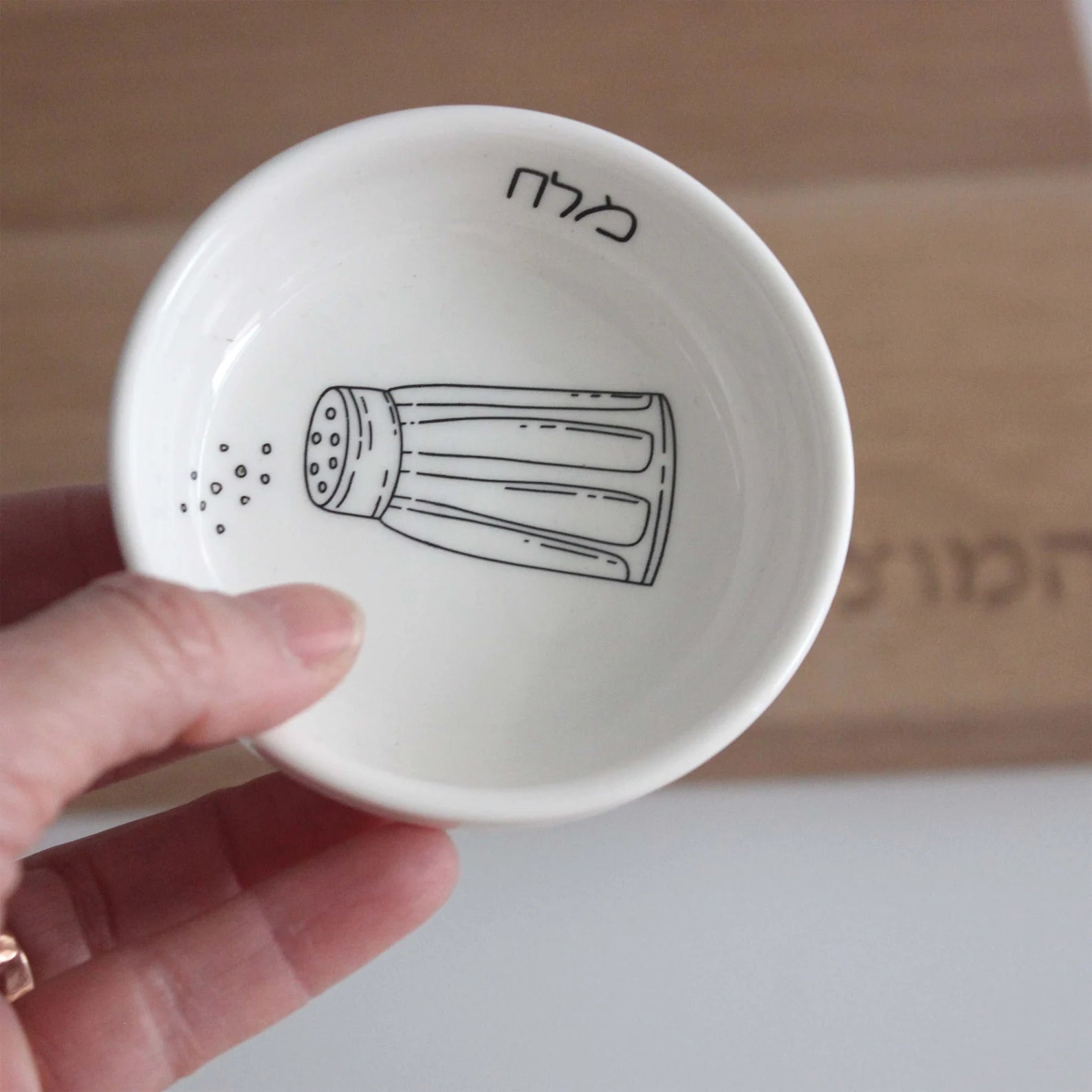 Porcelain bowl featuring an illustration of a black and white salt shaker