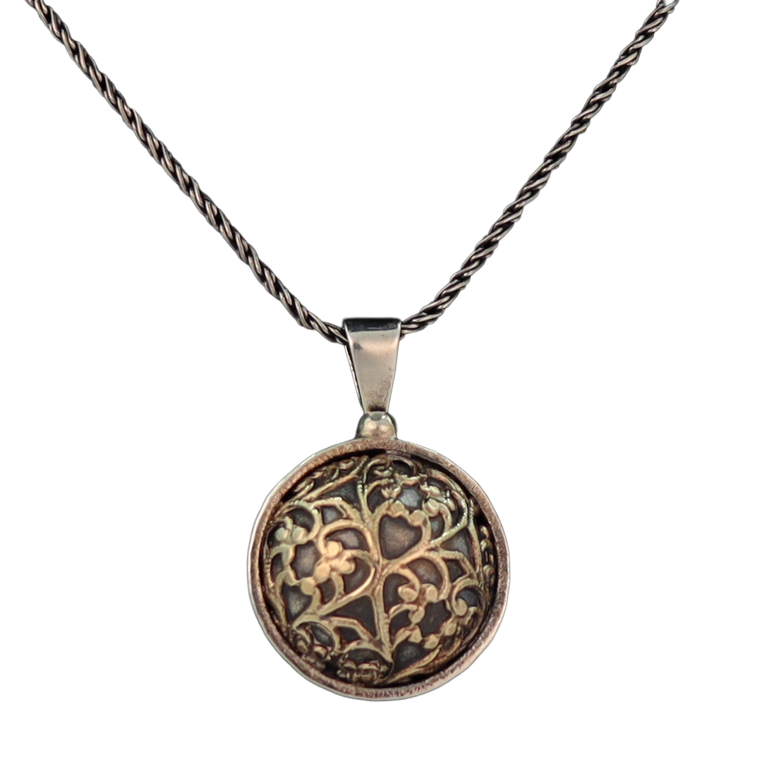 Round dome shaped pendant with gold pattern on black background