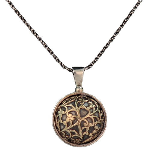 Round dome shaped pendant with gold pattern on black background