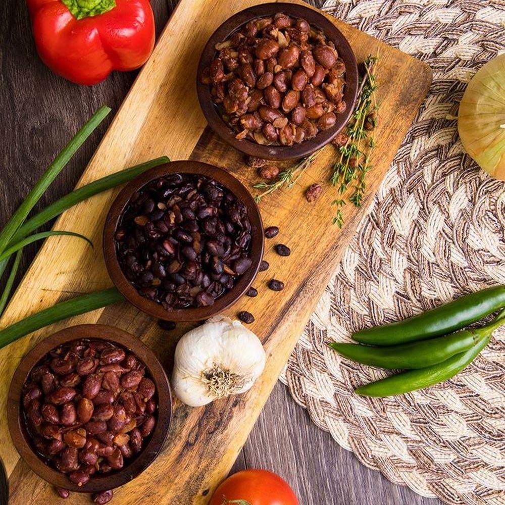 black beans pinto beans red beans in brown bowl with onion pepper tomato and herbs at side