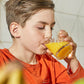 A boy drinking a glass of orange juice