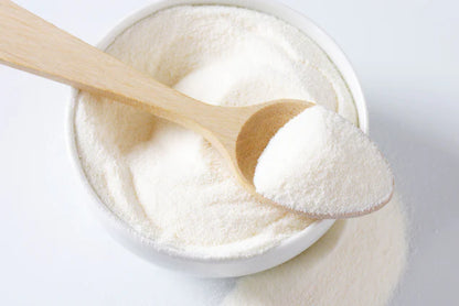 white bowl filled with whey powder overflowing with wooden spoon on top