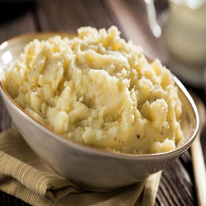 fluffy mashed potatoes in white bowl with green cloth under bowl 