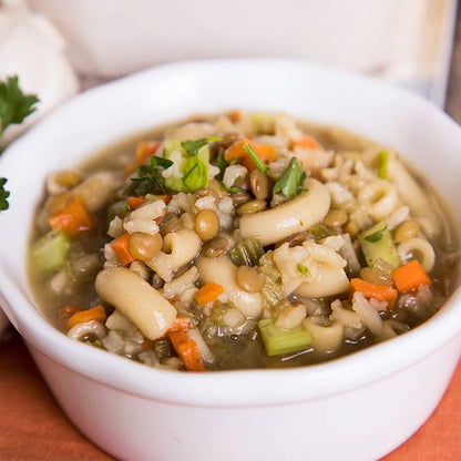 traveler's stew in white bowl on orange cloth with green garnish 