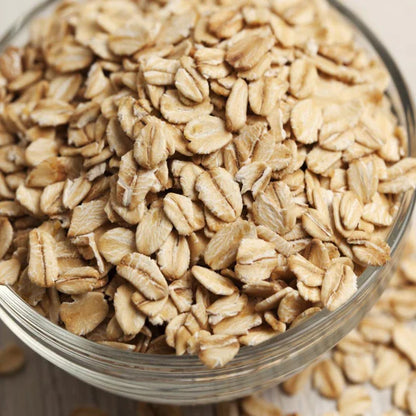 dry quick oats overflowing from glass bowl 