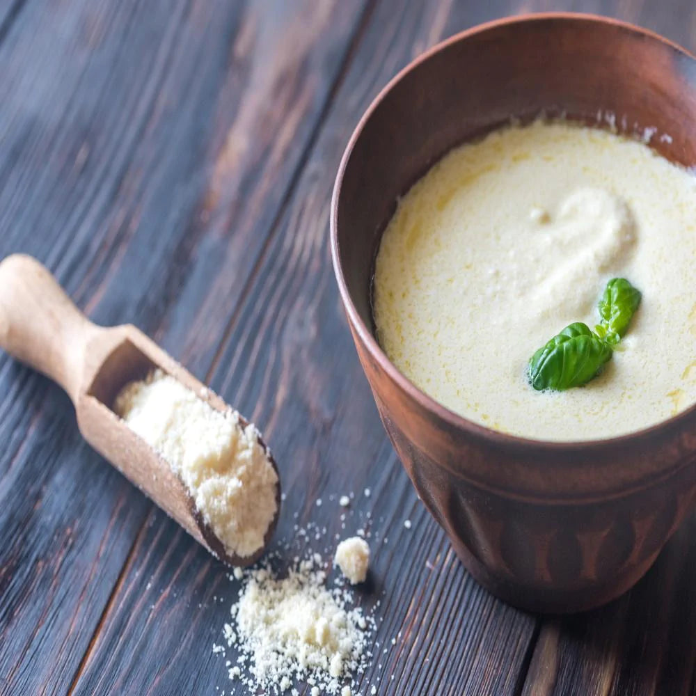 white sauce with green garnish on top in wooden bowl with parmesan cheese 