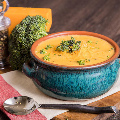 cooked cheesy broccoli and rice with broccoli and silver spoon on either side 