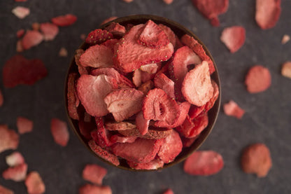 dried strawberries overflowing from bowl with dried strawberries around bowl