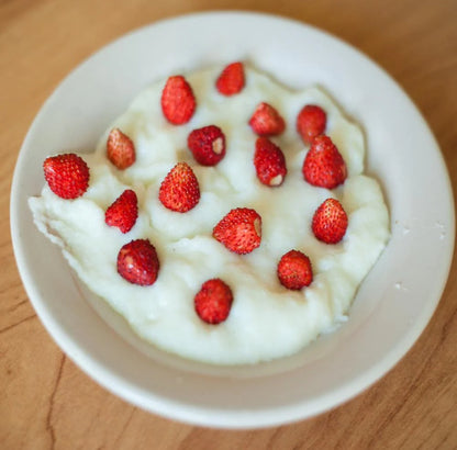 strawberry flavored cream of wheat with strawberries on top in white bowl