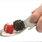 grub n tool being used as a spoon to pickup a raspberry and a blackberry