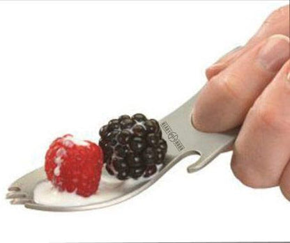 grub n tool being used as a spoon to pickup a raspberry and a blackberry