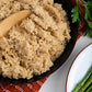 up close mushroom rice pilaf in black bowl with wooden spatula sticking out 